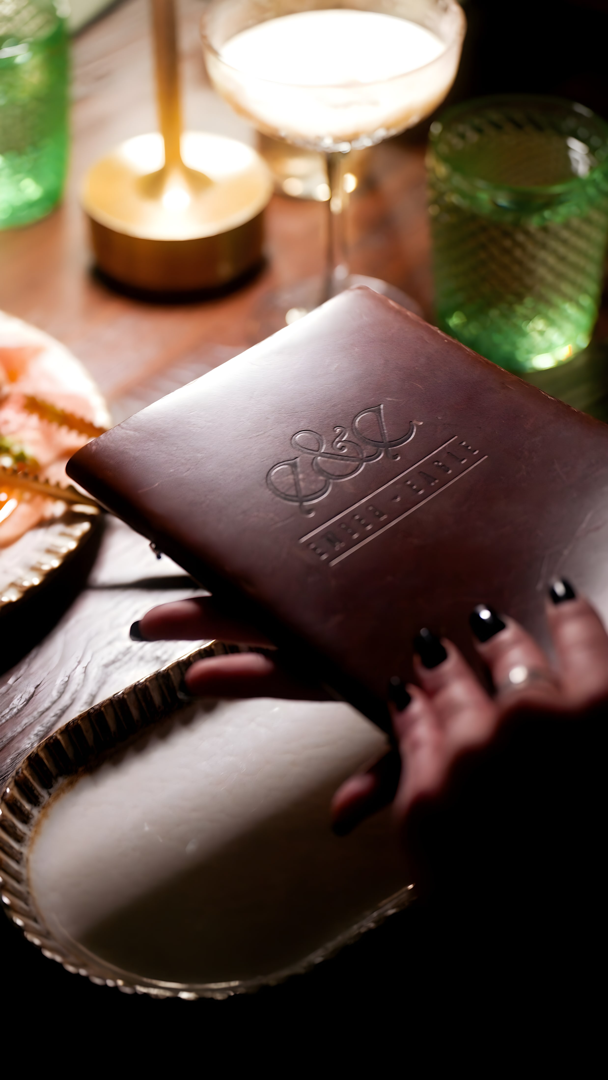 A guest holds the embossed Ember & Eagle menu