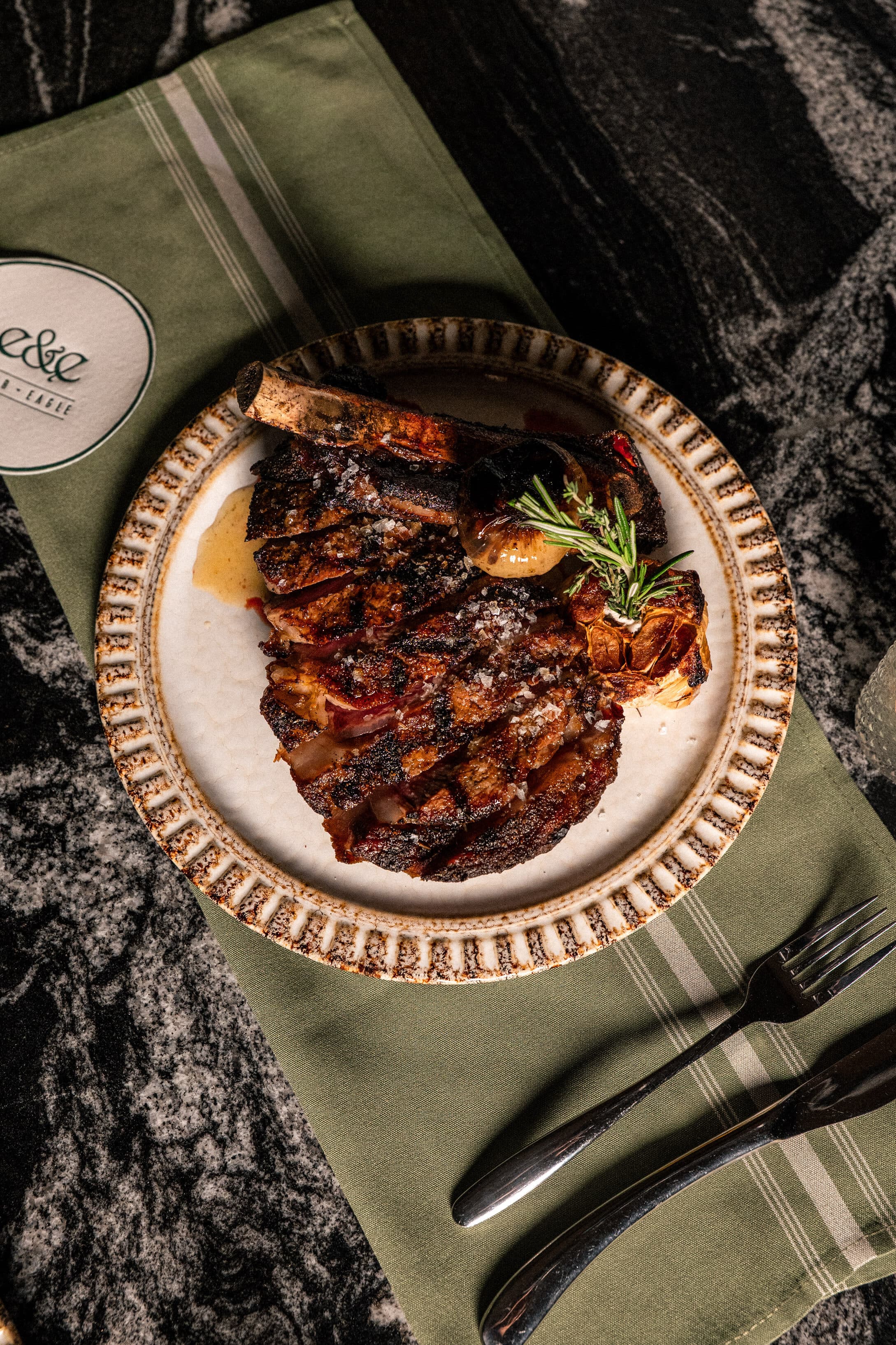 Sliced prime dry-aged steak plated at Ember & Eagle, Eatontown NJ